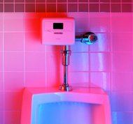 Retrofit direct flush installation in which the flushometer has been replaced with a sensor-operated system that automatically flushes the fixture when a user departs. The system uses an infrared proximity sensor to detect a user approaching the fixture, then it waits until the user departs. A solenoid is used to actuate the flush from a 6 volt battery inside the unit that also powers the sensor circuit.