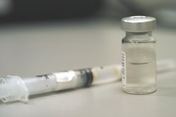 A bottle and a  containing the  vaccine.