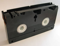 Bottom view of VHS videotape cassette with magnetic tape exposed