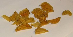 Chips from Russet baking potatoes, a variety high in sugar.  The dark color comes from caramelization.