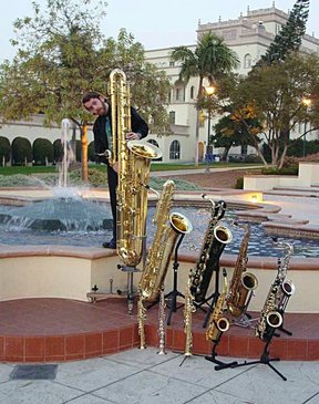 Jay C. Easton with ten members of the saxophone family. From largest to smallest: contrabass, bass, baritone, tenor, C tenor, alto, F mezzo-soprano, soprano, C soprano, sopranino.